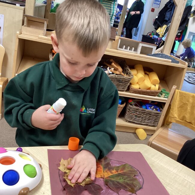 Infant boy finger painting at nursery.