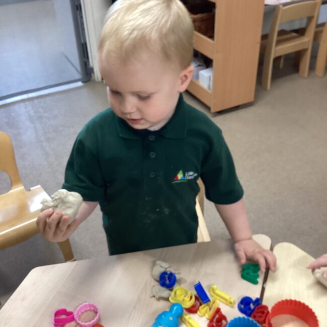 Infant boy playing with toys at nursery.